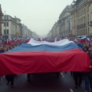Люди несут по улице флаг России: флаг